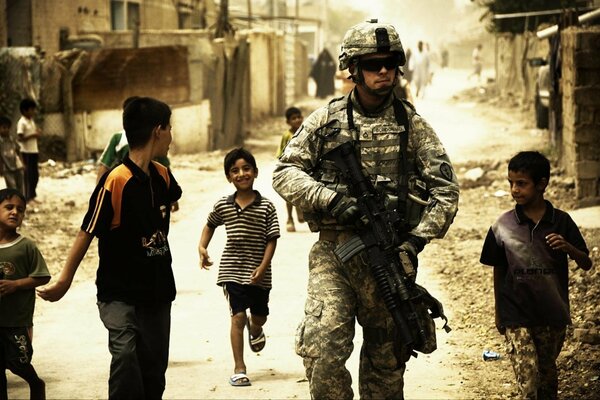 A soldier in the city. Children are running after him