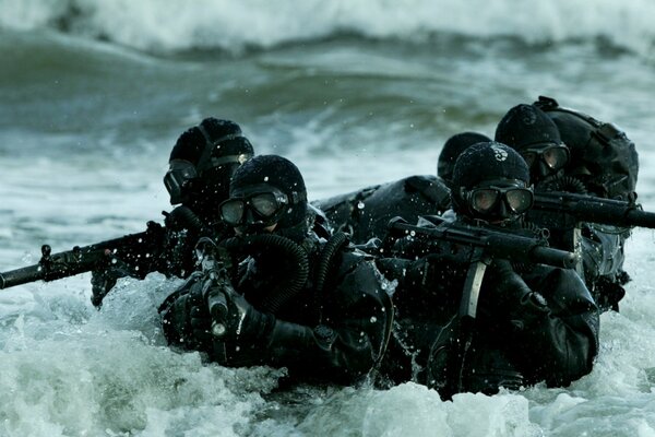 Un grupo de fuerzas especiales navales en el mar con un arma automática