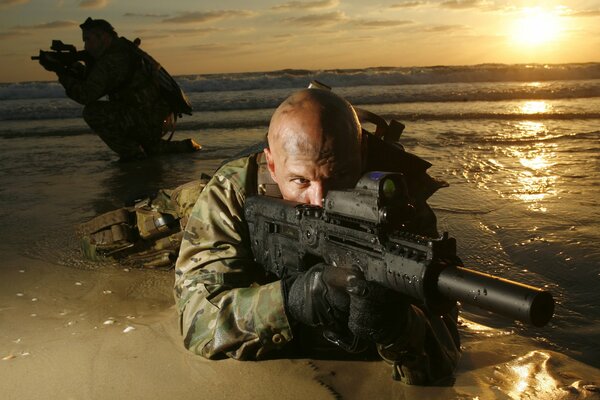 Glatzköpfiger Soldat liegt im Sand