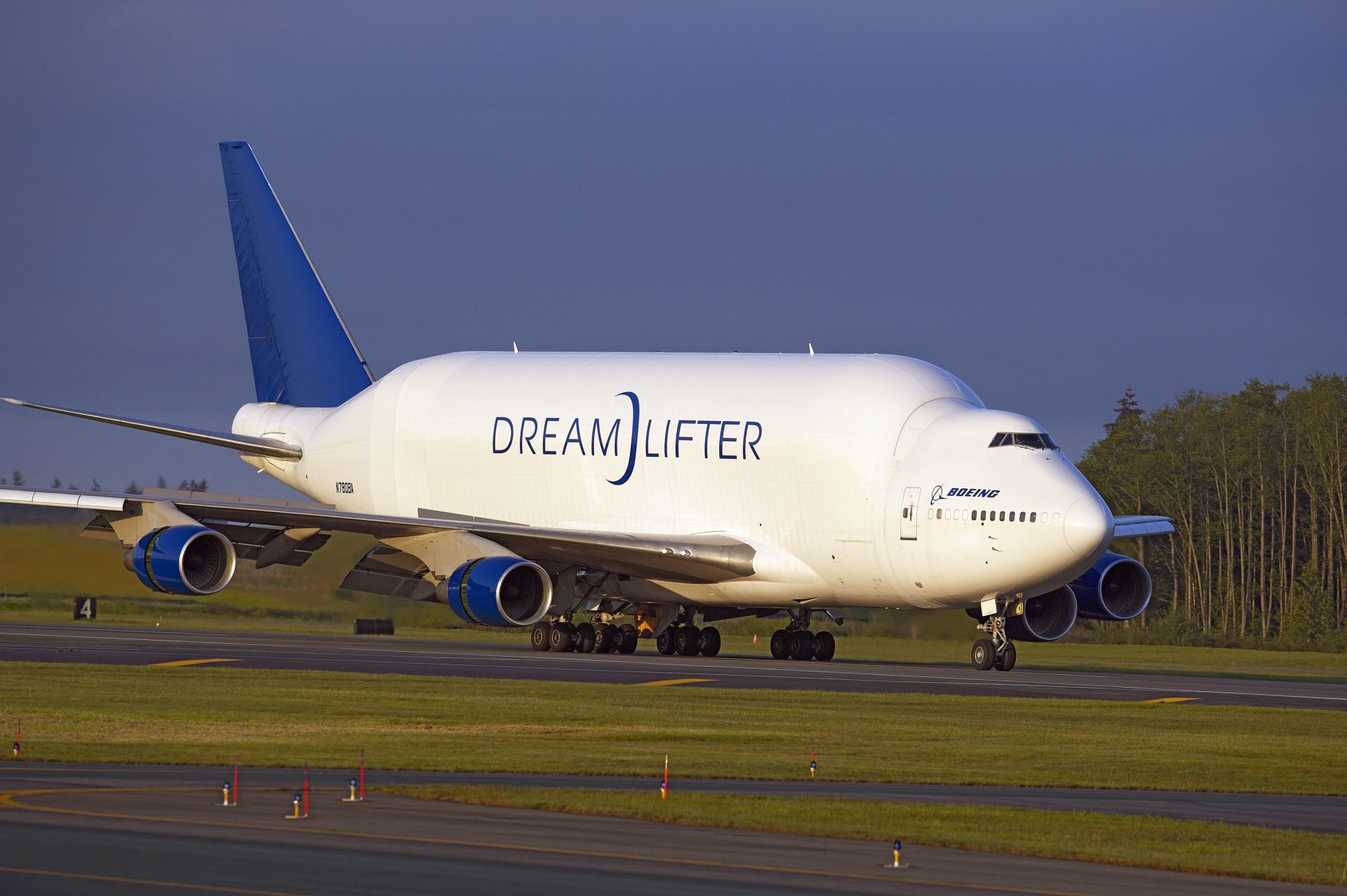 dreamlifter boeing aereo cargo aeroporto atterraggio decollo pista ali motori carrello di atterraggio alberi cielo aereo decollo pista