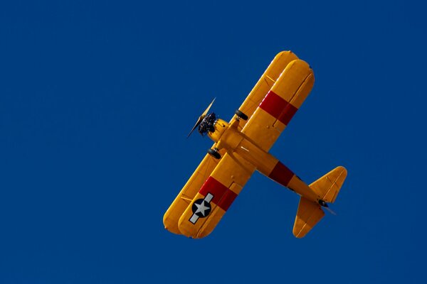 Biplane yellow against the blue sky