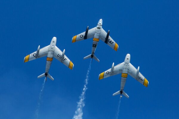 Trois avions volent dans le ciel bleu