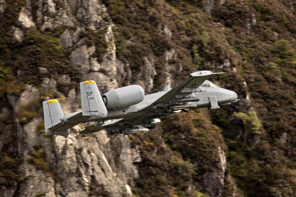 Transport plane flying on the background of rocks