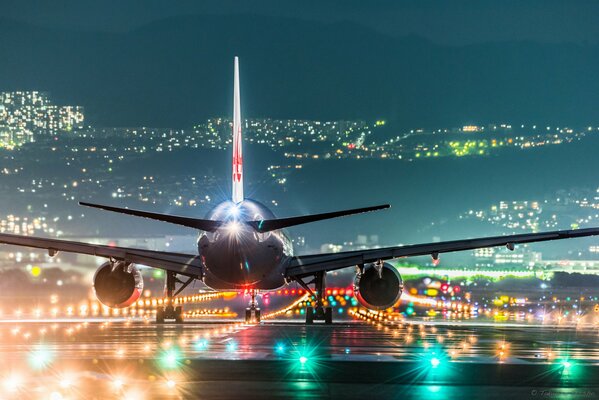 Passagierflugzeug in den Lichtern der Nachtstadt