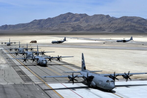 There are planes on the road against the background of mountains