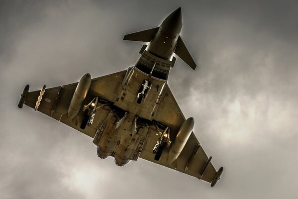 A fully activated fighter jet flies in a cloud of smoke