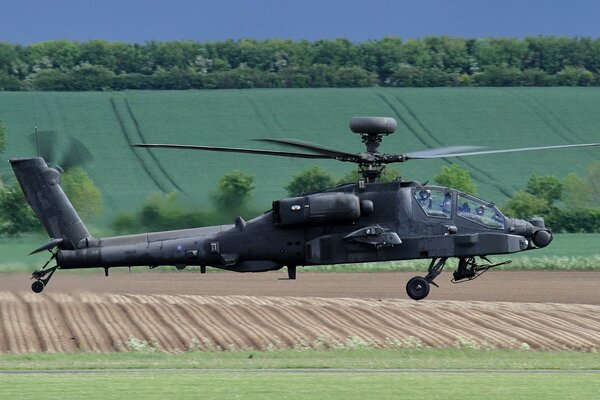 Un hélicoptère apache ah-64 survole les champs