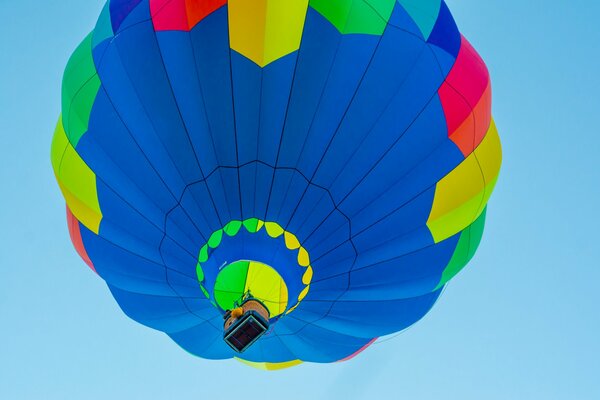 Flying a balloon with a basket in the blue sky