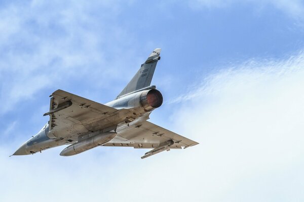 A military plane is flying in the sky