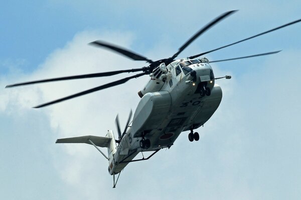 Fliegender Hubschrauber auf Himmelshintergrund mit Wolken