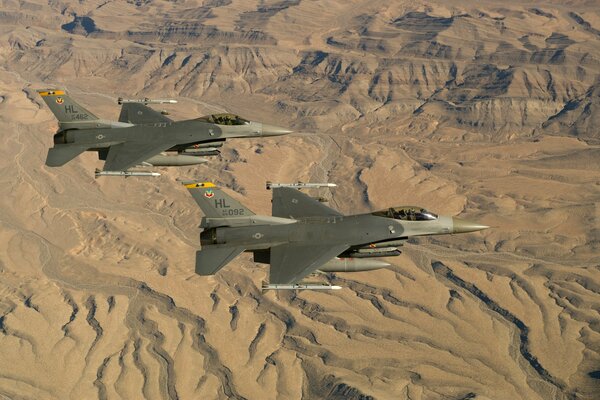 Dos F-16 Fighting falcon vuelan en medio del desierto