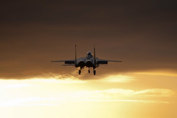 A plane is flying in the beautiful yellow sky