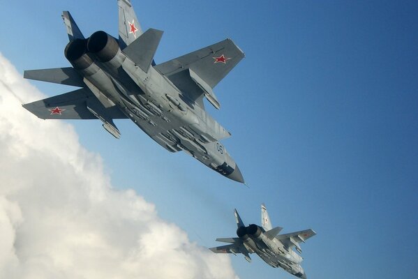 Two Russian mig-31 aircraft in flight bottom view