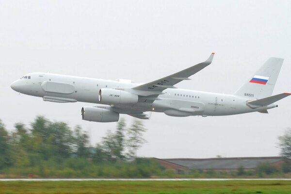 The Tu-214 aircraft flies very low above the ground without a highway