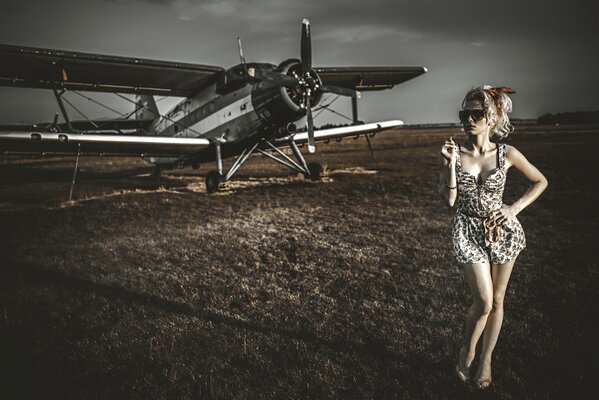 Beautiful blonde on the background of a biplane