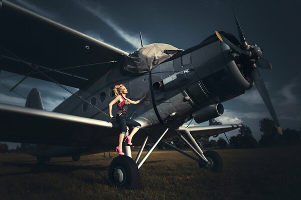 Enorme avión biplano en el campo y chica modelo