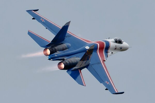 Vuelo del caza su-27 en el cielo gris