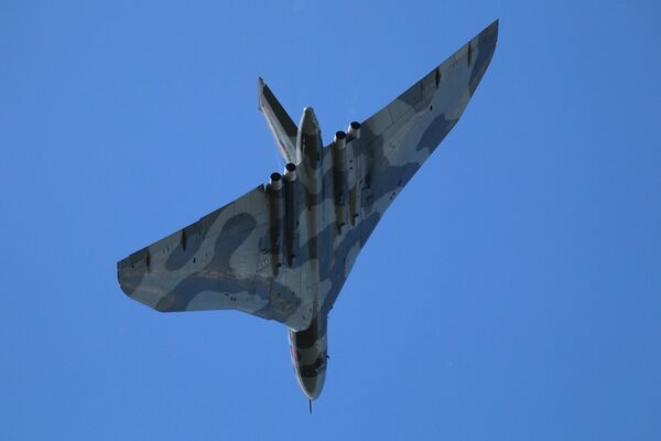 Un avion en camouflage vole dans le ciel