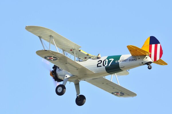 Avion biplan US Coast Guard vole dans le ciel bleu