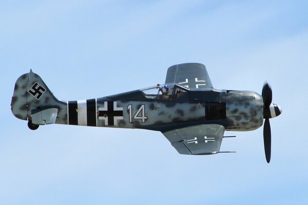 Fascist fighter with a pilot inside on a blue sky background