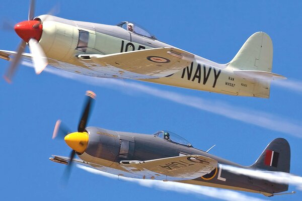 A parade of fighter jets with propellers in the sky