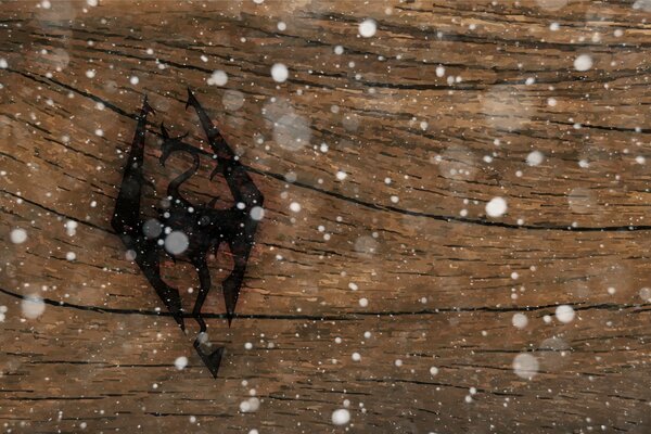 Das Logo des Computerspiels Skyrim, das auf die Oberfläche des Baumes aufgetragen ist