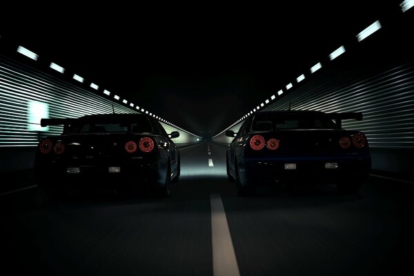 Two black cars driving on a night road