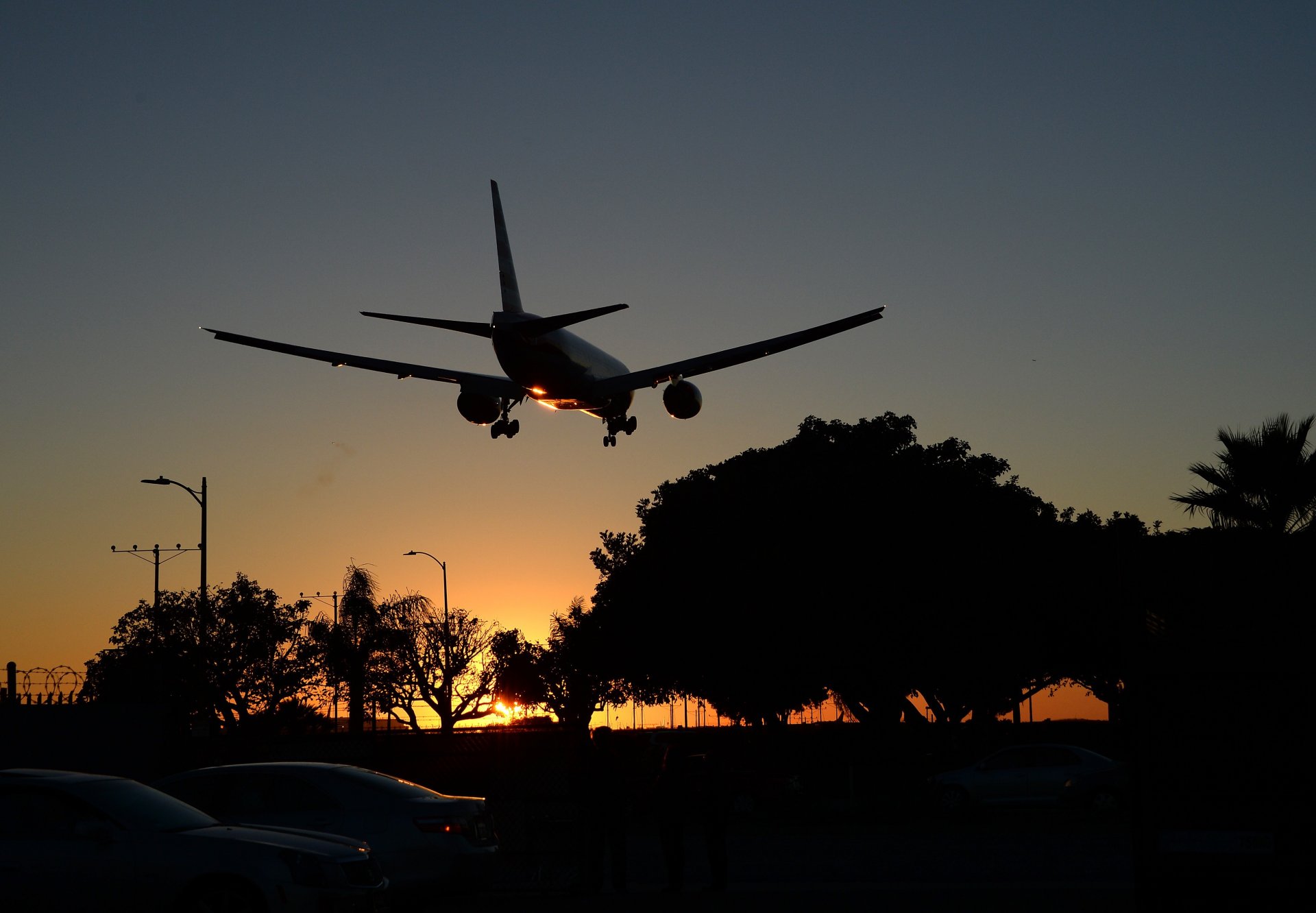 pasażer samolot boeing er samolot lądowanie lotnisko podwozie niebo zachód słońca słońce drzewa lato miasto ulica samochody pasażer samolot lato ulice samochody