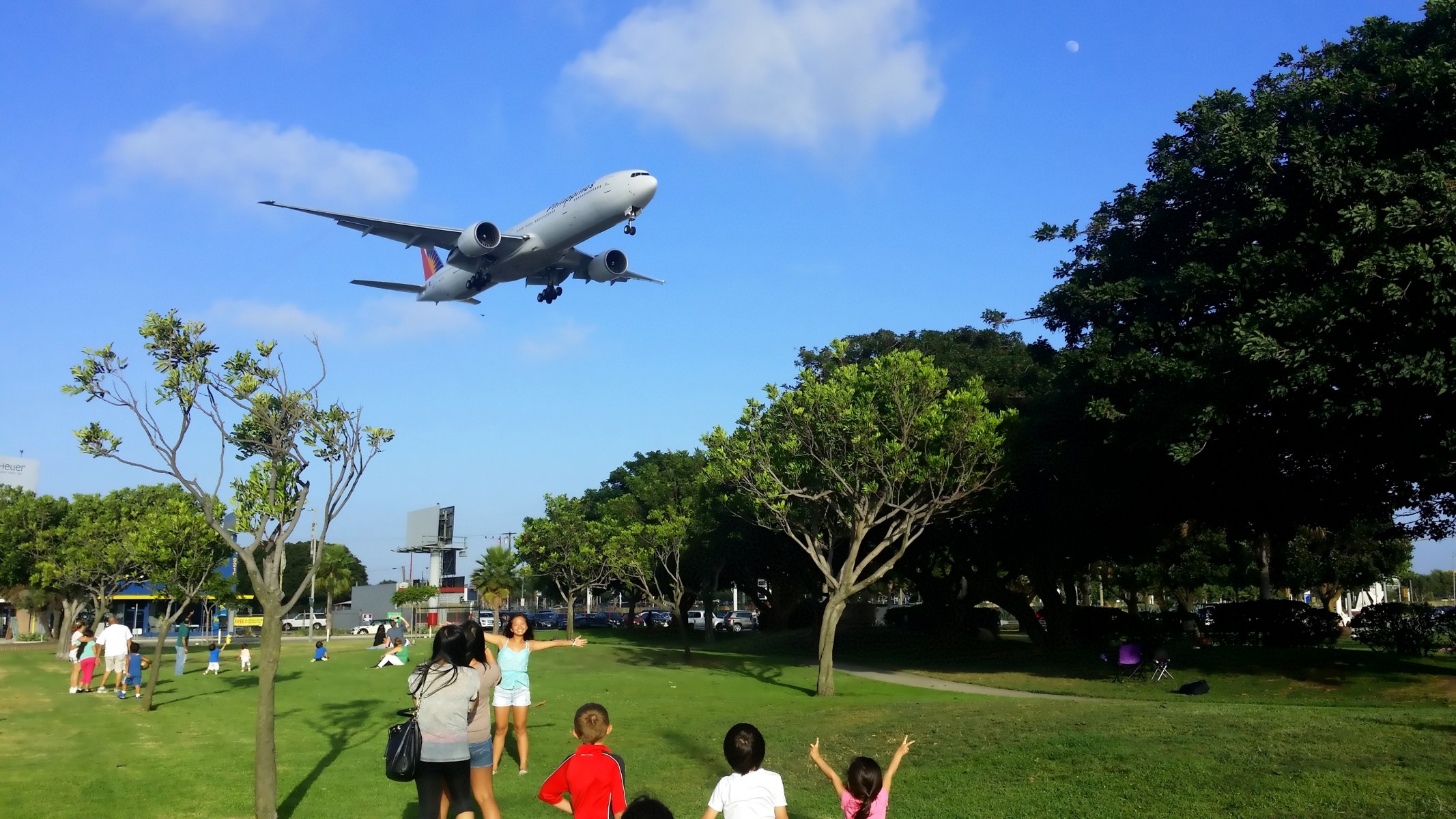 passenger airliner boeing er philippines airline plane landing landing gear sky clouds people park trees summer passenger plane person summer