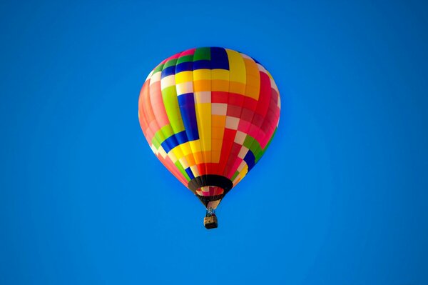 Volar un globo en el cielo azul