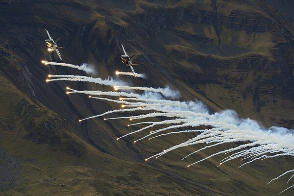 Kampfjets fliegen durch den Himmel und geben weißen Rauch frei