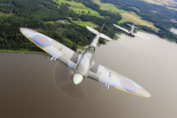 Avión de combate vuela sobre un río ancho