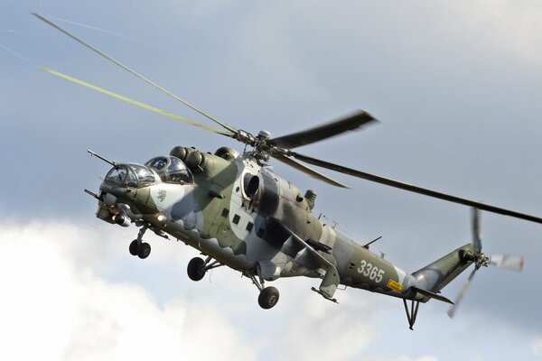 The Mi-24V transport and combat helicopter is flying in the sky