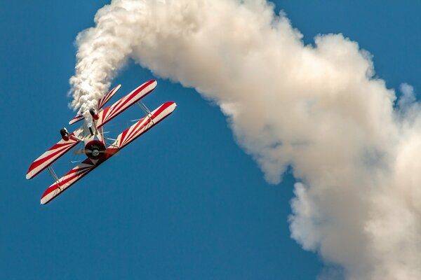 A plane flies in the blue sky and leaves traces