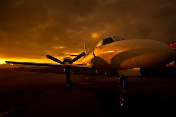 Flugzeug auf dem Flugplatz bei Sonnenuntergang