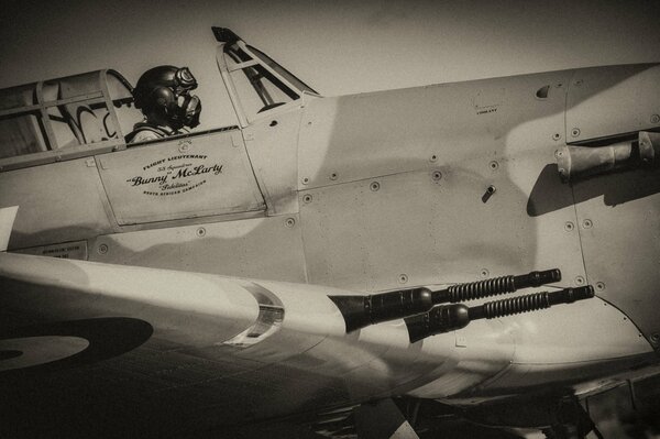 A pilot in the open cockpit of a World War II fighter jet