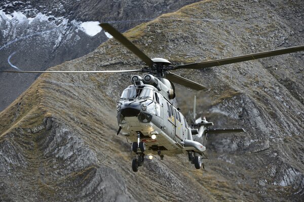 Un hélicoptère Puma polyvalent survole les montagnes