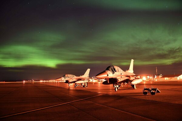 Vista notturna dell aerodromo con aereo e aurora boreale