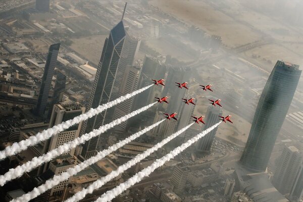 Red arrows fly in the sky over the city