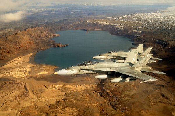 Dos aviones de combate vuelan sobre un hermoso ladshaft