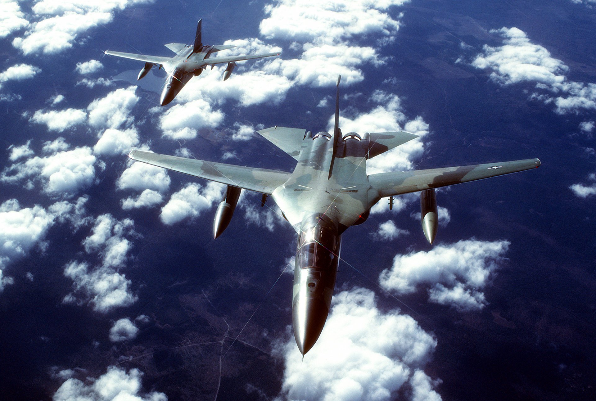 general dynamics f-111 tactical bomber variable sweep wing flight clouds the pair sky