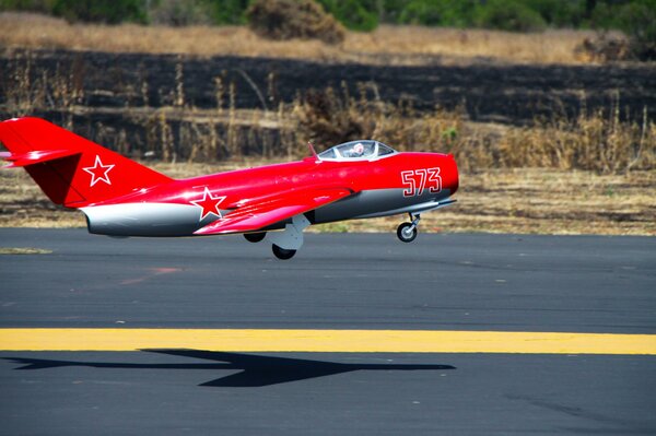 A red plane taking off with a star