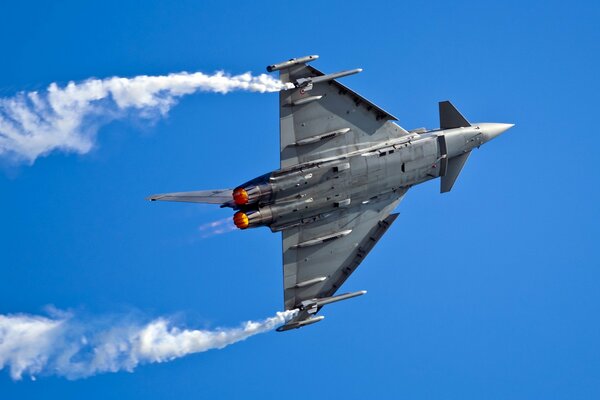 Avión militar en el cielo azul brillante