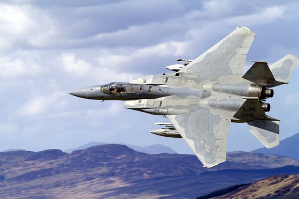 Avión de combate militar en el cielo sobre las montañas