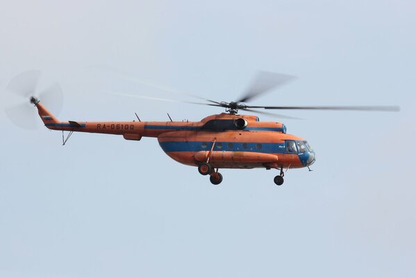 Russischer Mehrzweckhubschrauber in orange-blauer Färbung vor dem Hintergrund des MI-8 -Himmels.