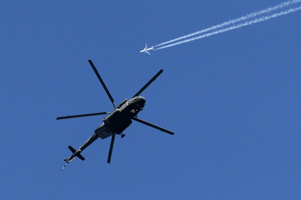 A Russian Air Force Mi-17 helicopter, and a Boeing-737 is flying in the background