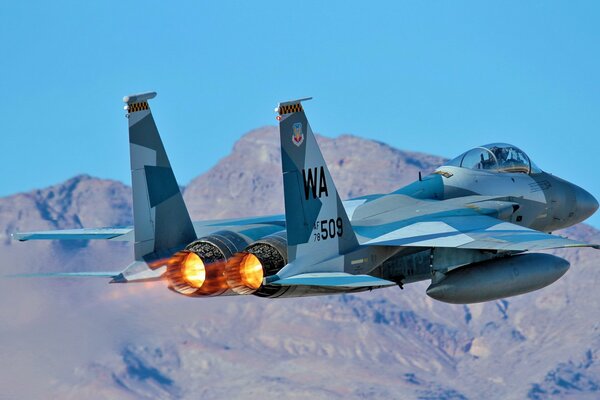 Fighter in the air rear view with burning engines