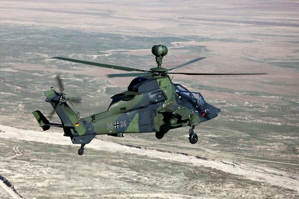 Military helicopter in the sky over the desert