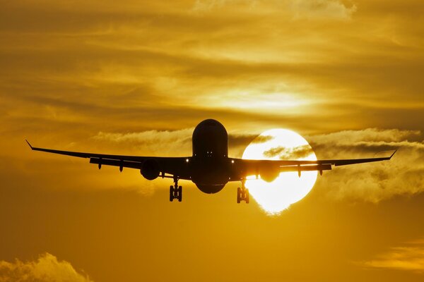 Avión de pasajeros en medio de la puesta de sol