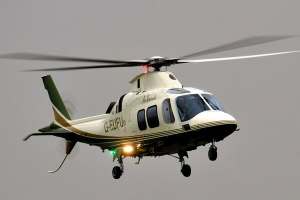 An eight-seat helicopter against a gray sky